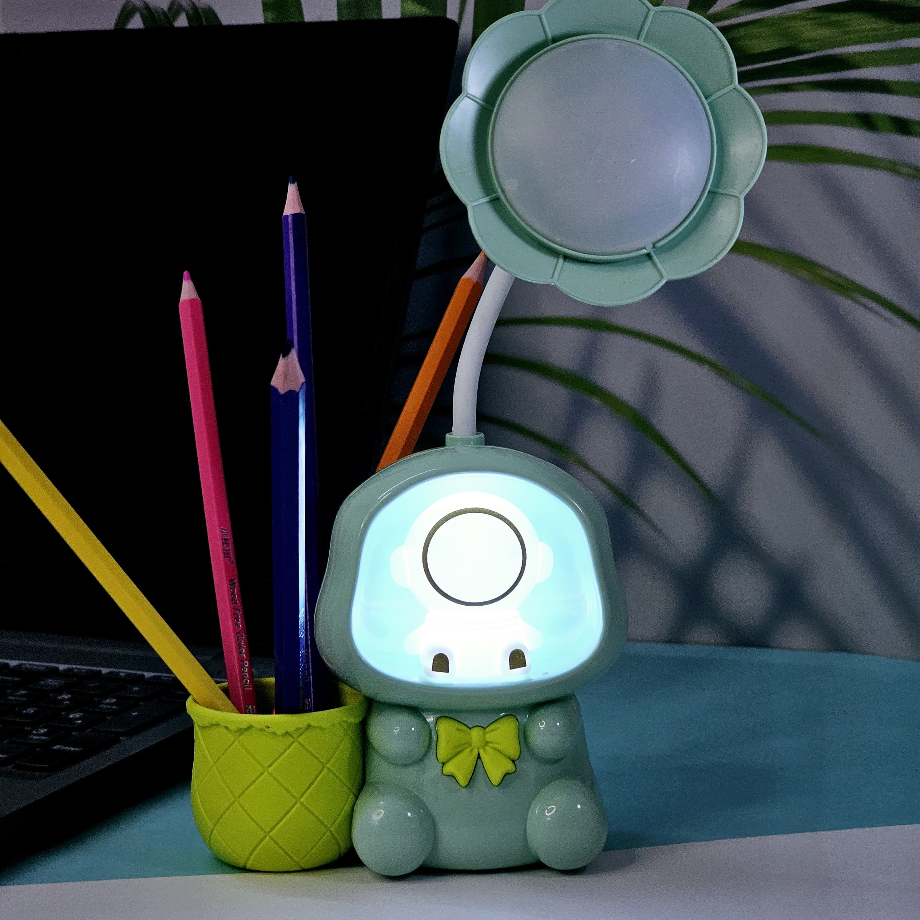 "Usmile Toys multifunctional kids' lamp: a blue, pink, and green astronaut figure with a flower-petal light and an integrated pencil holder, enhancing study time and room decor." www.usmile.toys